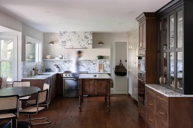 McLean, VA kitchen with walnut cabinets, black glass-front cabinetry, a marble backsplash and a wood island