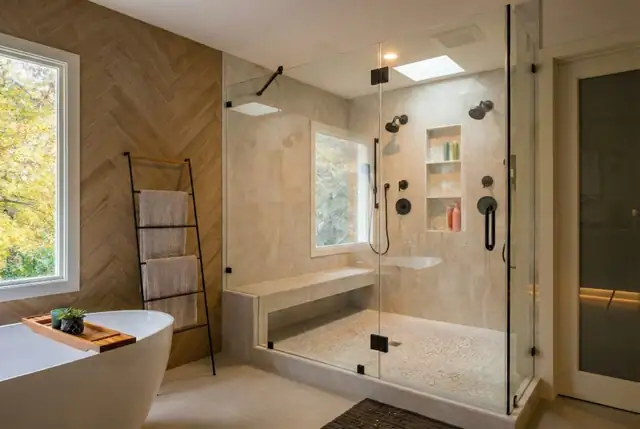 McLean, VA bathroom with a frameless glass walk-in shower, built-in bench, black fixtures and a herringbone wood-look tile wall