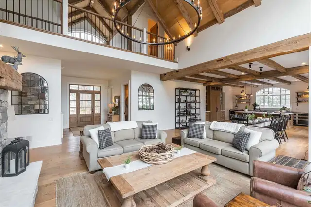 Reston, VA whole house remodel with a two-story great room, exposed timber ceiling beams, a loft railing and an iron ring chandelier